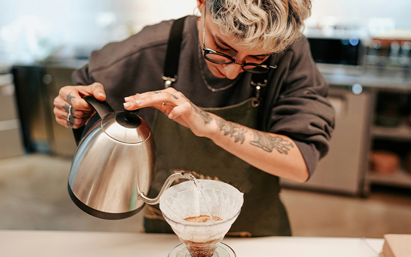 Barista preparing coffee with professional equipment